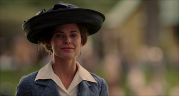 Movie still from “The Greatest Game Ever Played” (2005), directed by Bill Paxton – A woman wearing a black hat and a white shirt; Close Up shot, Low angle