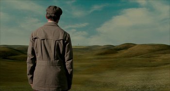 Movie still from “The Greatest Game Ever Played” (2005), directed by Bill Paxton – A man standing in the middle of an empty field; Extreme Wide shot, High angle