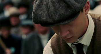 Movie still from “The Greatest Game Ever Played” (2005), directed by Bill Paxton – A man wearing a hat and a tie; Close Up shot, Low angle