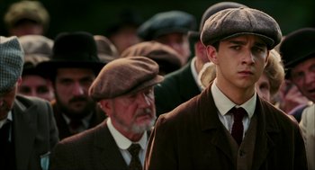 Movie still from “The Greatest Game Ever Played” (2005), directed by Bill Paxton – A group of men wearing hats and suits; Close Up shot, Low angle