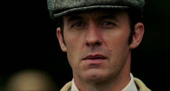 Movie still from “The Greatest Game Ever Played” (2005), directed by Bill Paxton – A person wearing a hat; Close Up shot, Low angle