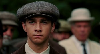 Movie still from “The Greatest Game Ever Played” (2005), directed by Bill Paxton – A young man wearing a hat and a jacket; Close Up shot, High angle