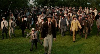 Movie still from “The Greatest Game Ever Played” (2005), directed by Bill Paxton – A group of men in suits and hats walking through a field; Wide shot, High angle