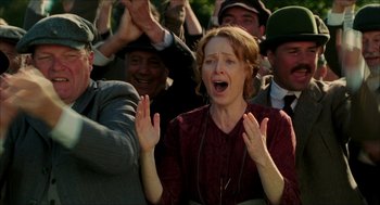 Movie still from “The Greatest Game Ever Played” (2005), directed by Bill Paxton – A group of people that are standing in the grass; Medium shot, Low angle