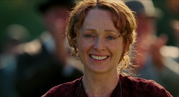 Movie still from “The Greatest Game Ever Played” (2005), directed by Bill Paxton – A person smiling for the camera; Close Up shot, Over the shoulder angle