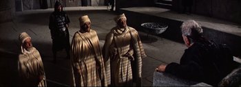 Movie still from “The Greatest Story Ever Told” (1965), directed by David Lean – A couple of men standing next to each other on top of a sidewalk; Medium shot, High angle