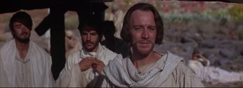Movie still from “The Greatest Story Ever Told” (1965), directed by David Lean – A man with a beard is wearing a white robe; Close Up shot, Over the shoulder angle
