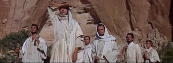 Movie still from “The Greatest Story Ever Told” (1965), directed by David Lean – A group of men standing next to each other in white robes; Medium shot, Low angle