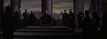 Movie still from “The Greatest Story Ever Told” (1965), directed by David Lean – A group of men standing around a pillar; Wide shot, Low angle