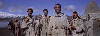 Movie still from “The Greatest Story Ever Told” (1965), directed by David Lean – A group of men standing next to each other in a field; Medium shot, Low angle