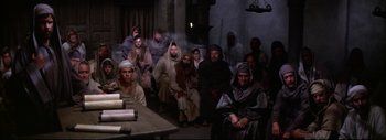 Movie still from “The Greatest Story Ever Told” (1965), directed by David Lean – A group of people dressed in robes sitting in a room; Wide shot, High angle