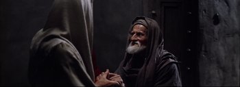 Movie still from “The Greatest Story Ever Told” (1965), directed by David Lean – An old man with a long beard is talking to another man; Medium shot, Over the shoulder angle