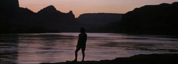 Movie still from “The Greatest Story Ever Told” (1965), directed by David Lean – A man standing on a rock near a body of water; Extreme Wide shot, Low angle