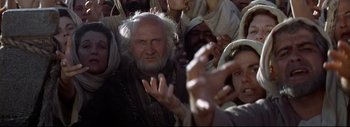 Movie still from “The Greatest Story Ever Told” (1965), directed by David Lean – An old man with a beard and white hair is surrounded by people; Medium shot, Low angle
