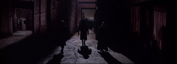 Movie still from “The Greatest Story Ever Told” (1965), directed by David Lean – A group of people walking down a street at night; Wide shot, Low angle