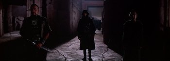 Movie still from “The Greatest Story Ever Told” (1965), directed by David Lean – A man in a trench coat standing in a dark alley way; Wide shot, Low angle
