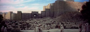 Movie still from “The Greatest Story Ever Told” (1965), directed by David Lean – A group of people standing in front of a stone wall; Extreme Wide shot, High angle