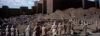 Movie still from “The Greatest Story Ever Told” (1965), directed by David Lean – A group of people standing in front of a castle; Extreme Wide shot, High angle