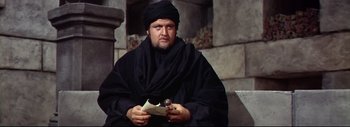 Movie still from “The Greatest Story Ever Told” (1965), directed by David Lean – A man in a black robe holding a piece of paper; Close Up shot, High angle