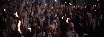 Movie still from “The Greatest Story Ever Told” (1965), directed by David Lean – A group of people with torches in their hands; Wide shot, High angle