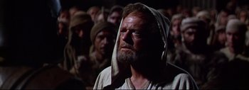 Movie still from “The Greatest Story Ever Told” (1965), directed by David Lean – A man with a towel on his head is looking up at a crowd; Close Up shot, Low angle