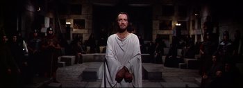 Movie still from “The Greatest Story Ever Told” (1965), directed by David Lean – A man wearing a white robe standing in front of a group of people; Medium shot, Low angle
