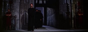 Movie still from “The Greatest Story Ever Told” (1965), directed by David Lean – A group of people standing in a dark alley way; Wide shot, Low angle