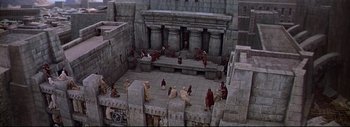 Movie still from “The Greatest Story Ever Told” (1965), directed by David Lean – A group of people sitting on top of a stone building; Extreme Wide shot, High angle