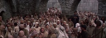 Movie still from “The Greatest Story Ever Told” (1965), directed by David Lean – A large group of people gathered together in a cave; Wide shot, High angle