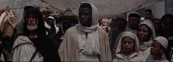 Movie still from “The Greatest Story Ever Told” (1965), directed by David Lean – A man wearing a white robe and a white head scarf; Medium shot, Low angle