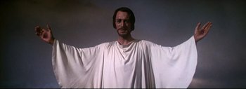 Movie still from “The Greatest Story Ever Told” (1965), directed by David Lean – A man in a white robe standing in front of a sky background; Medium shot, Low angle