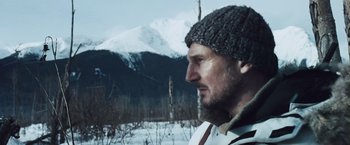 Movie still from “The Grey” (2011), directed by Joe Carnahan – A person wearing a hat in the snow; Close Up shot, Low angle