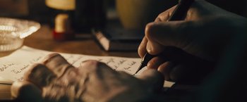 Movie still from “The Grey” (2011), directed by Joe Carnahan – A person writing on a piece of paper with a fountain pen; Extreme Close Up shot, High angle