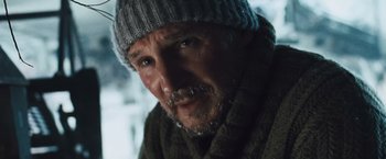 Movie still from “The Grey” (2011), directed by Joe Carnahan – A person wearing a sweater and a hat; Close Up shot, Low angle