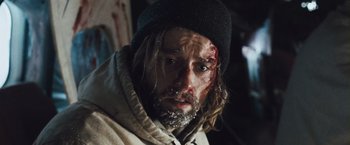 Movie still from “The Grey” (2011), directed by Joe Carnahan – A person wearing a hat and a jacket; Close Up shot, Low angle