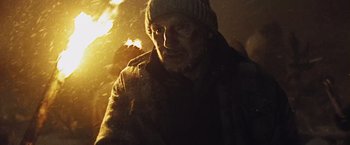 Movie still from “The Grey” (2011), directed by Joe Carnahan – A man with a beard and a hat is in the dark; Close Up shot, Low angle