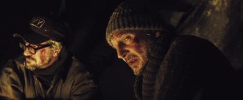 Movie still from “The Grey” (2011), directed by Joe Carnahan – A person wearing a sweater and a hat; Close Up shot, Low angle
