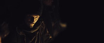 Movie still from “The Grey” (2011), directed by Joe Carnahan – A man in a black jacket and a black hat; Close Up shot, Over the shoulder angle