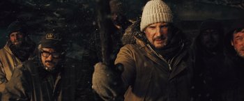 Movie still from “The Grey” (2011), directed by Joe Carnahan – A man holding a stick in the snow; Close Up shot, Over the shoulder angle
