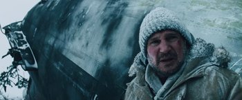 Movie still from “The Grey” (2011), directed by Joe Carnahan – A man wearing a winter hat and a coat; Close Up shot, Low angle