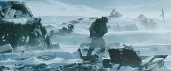 Movie still from “The Grey” (2011), directed by Joe Carnahan – A man walking through the snow with a backpack; Wide shot, High angle