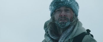 Movie still from “The Grey” (2011), directed by Joe Carnahan – A person wearing a jacket and a hat; Close Up shot, Low angle
