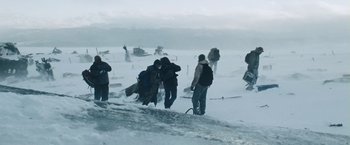 Movie still from “The Grey” (2011), directed by Joe Carnahan – A group of people standing on top of a snow covered slope; Extreme Wide shot, Low angle