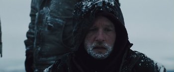 Movie still from “The Grey” (2011), directed by Joe Carnahan – A person wearing a hooded jacket; Close Up shot, Low angle