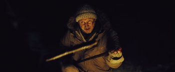 Movie still from “The Grey” (2011), directed by Joe Carnahan – A man holding a wooden stick in the dark at night; Close Up shot, Low angle