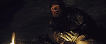 Movie still from “The Grey” (2011), directed by Joe Carnahan – A man in a hooded jacket and gloves looking at the camera; Close Up shot, High angle