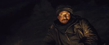 Movie still from “The Grey” (2011), directed by Joe Carnahan – A man with a hat and a jacket on; Close Up shot, Over the shoulder angle