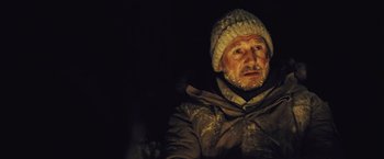 Movie still from “The Grey” (2011), directed by Joe Carnahan – A man in a jacket and a hat with snow on his face; Close Up shot, Over the shoulder angle