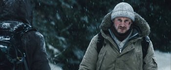 Movie still from “The Grey” (2011), directed by Joe Carnahan – A man wearing a winter coat and hat in the snow; Close Up shot, Low angle