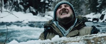 Movie still from “The Grey” (2011), directed by Joe Carnahan – A man with a beard and a hat in the middle of the snow; Close Up shot, Low angle